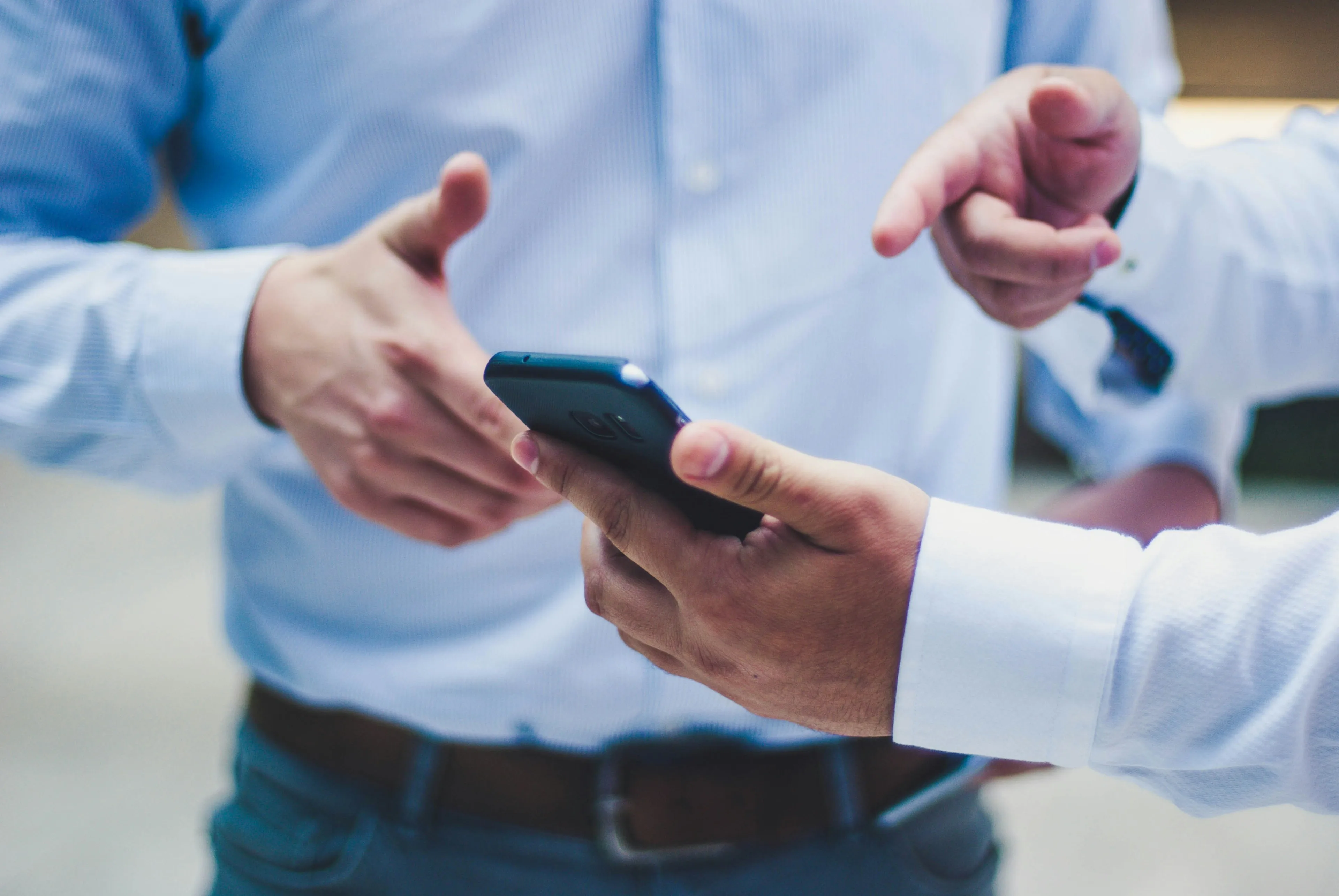 Asmuo, dalinantis informaciją telefono ekrane