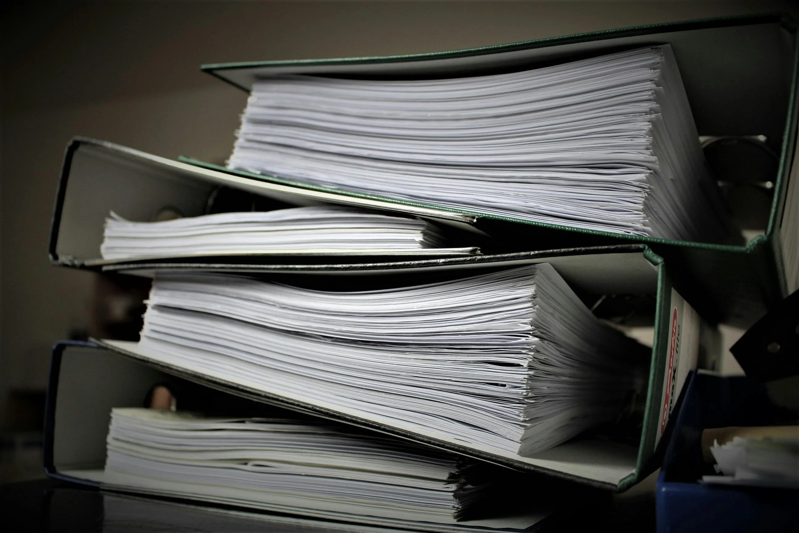 A large pile of paper binders with a lot of documents