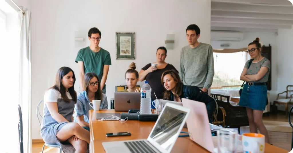 Team watching something on the screen of a laptop