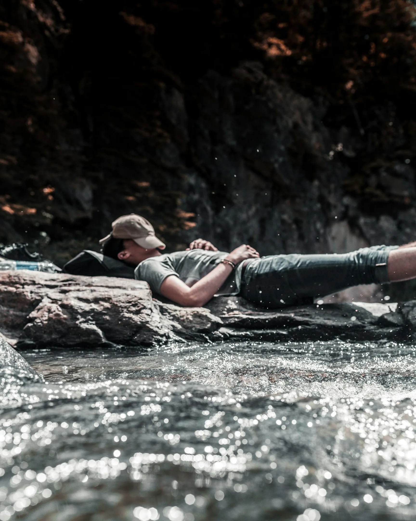 A man lying next to a river