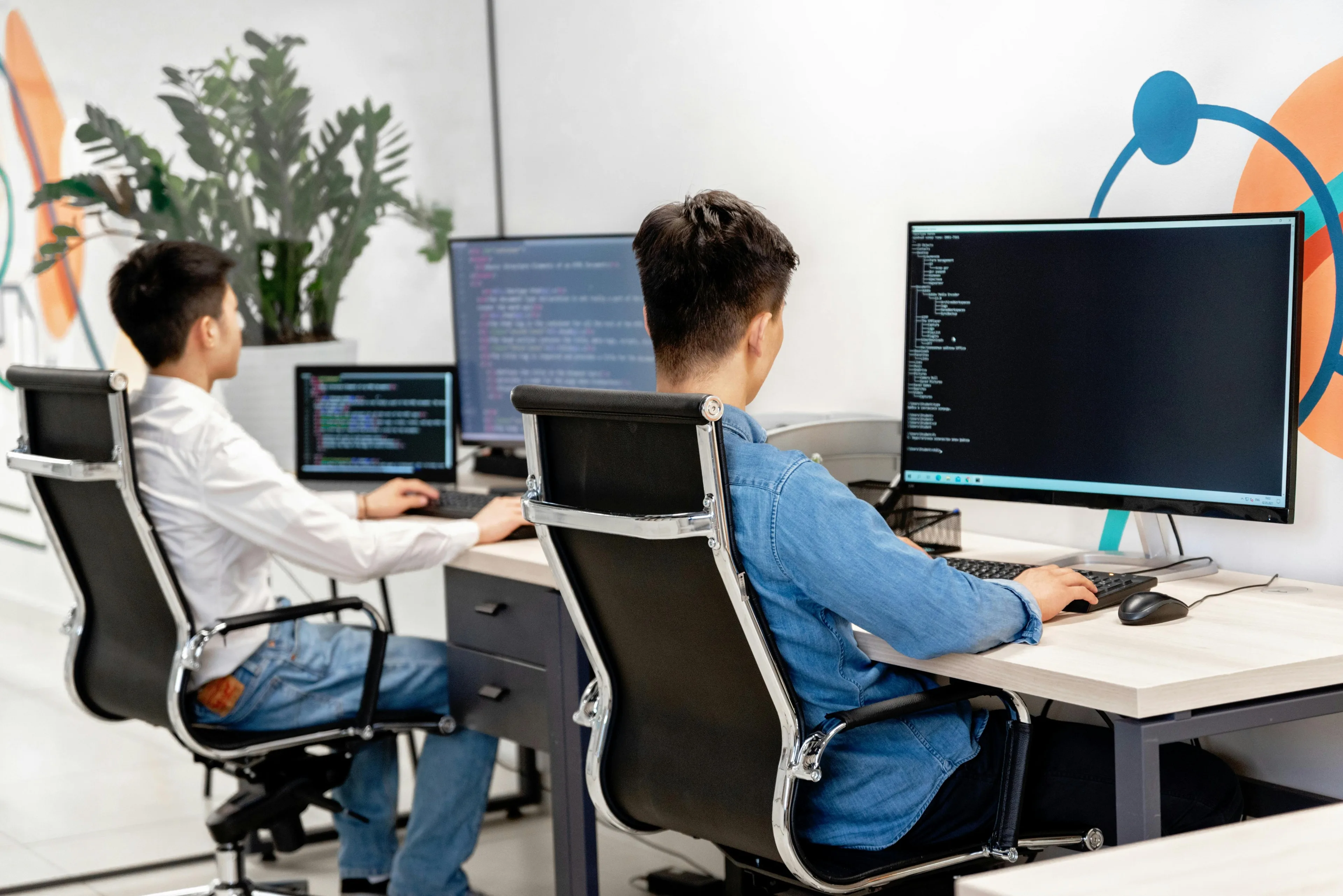 Du programinės įrangos kūrėjai biure prie stalinių kompiuterių