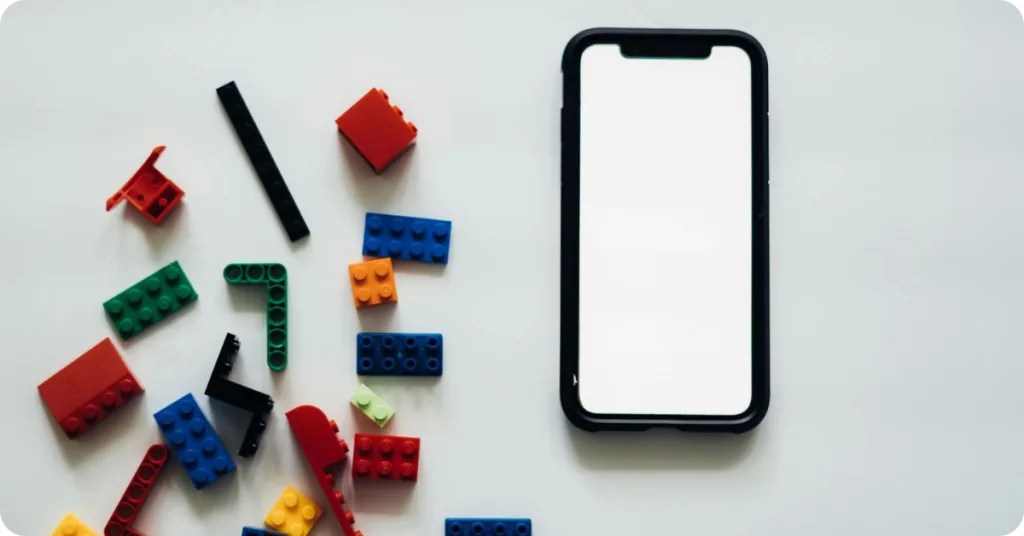 Lego building blocks and smartphone with white screen